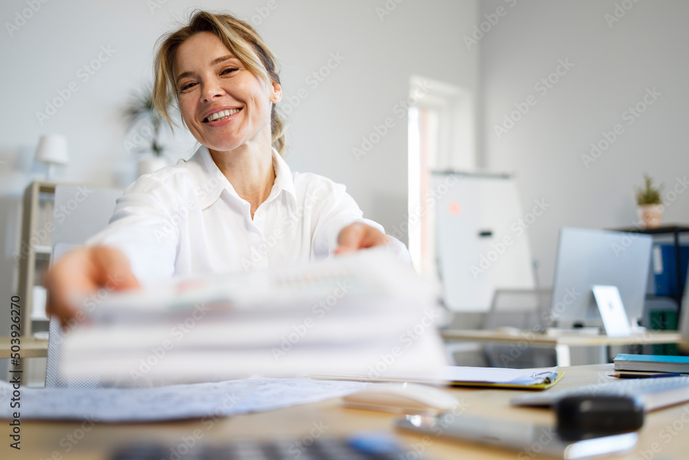 Smiling female bank employee giving a contract Smiling female bank employee giving a contract