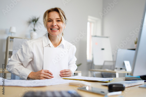 Tableau sur toile Pleasant business woman with paper sitting at the workplace