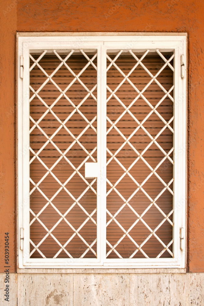 Closeup of a window with the shutter and wing grate closed. Closeup of a window with the shutter and wing grate closed.