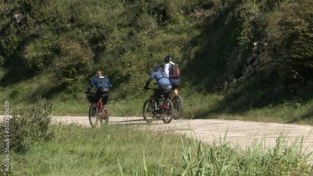 Three cyclists climb the mountain's entrance by bicycle. Three cyclists climb the mountain's entrance by bicycle.