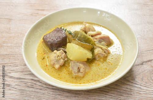 spicy boiled slice winter melon with chicken and blood in coconut milk green curry soup on plate