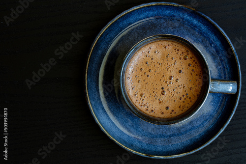 blue cup of coffee on black background © Ruslan