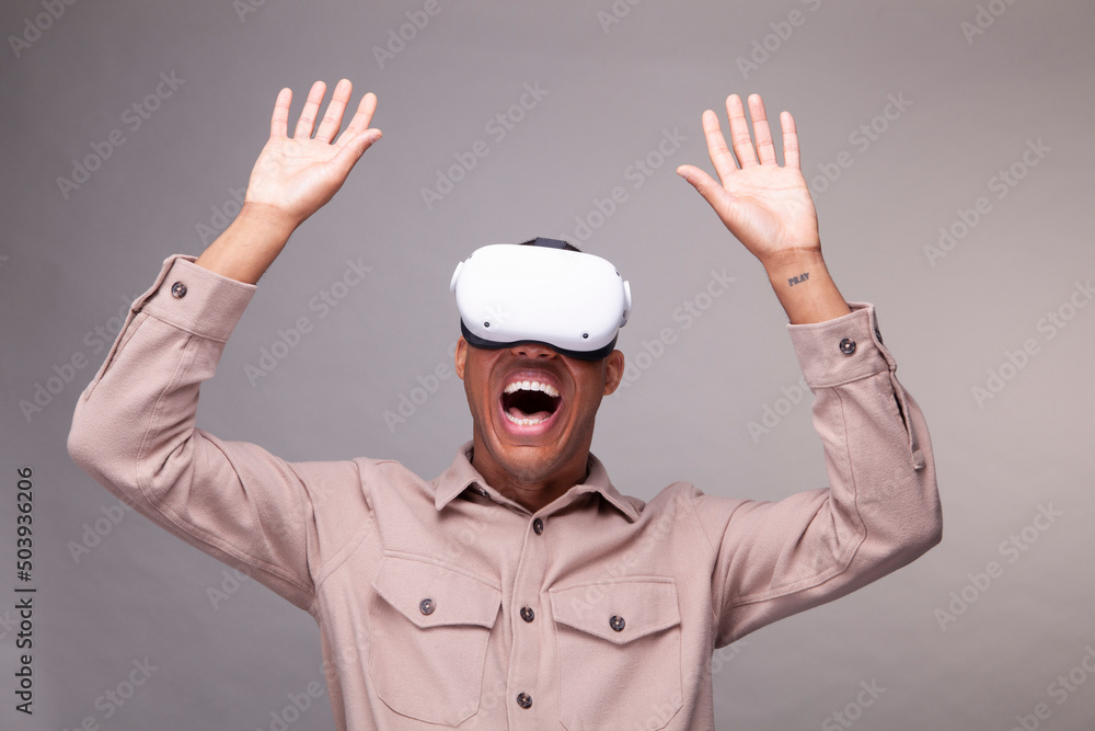 Man in virtual reality headset raising hands Man in virtual reality headset raising hands