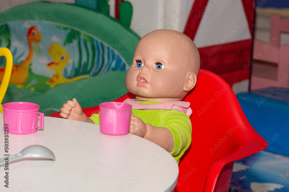Doll sitting at table having tea Doll sitting at table having tea