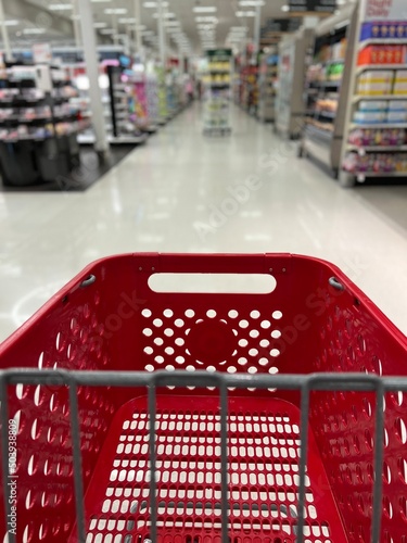Red grocery shopping cart in the blurred aisles of a Target store.