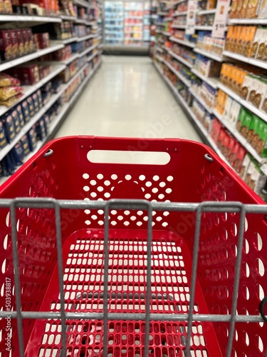 Red grocery shopping cart in the blurred aisles of a Target store.