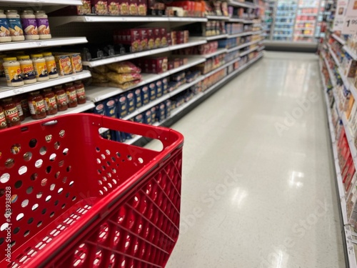 Red grocery shopping cart in the blurred aisles of a Target store.
