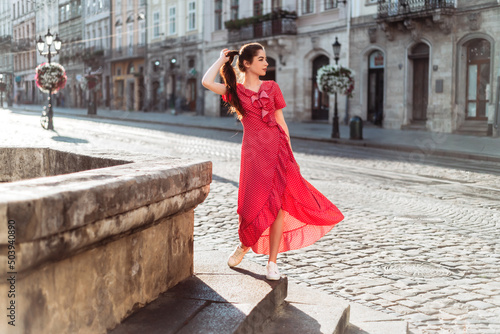 Amazing girl with long hair in summer outfit walk on old city street