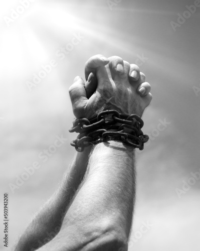 Chained hands praying for help