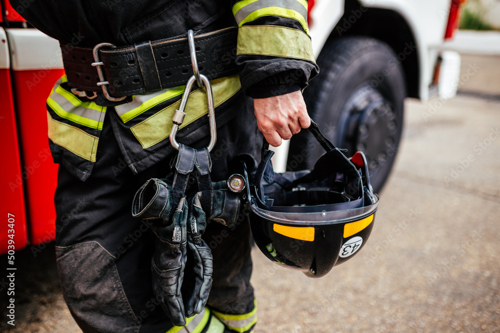 Black helmet in fireman's hand close-up