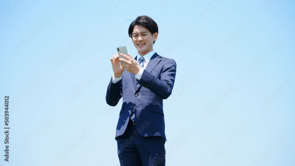 スマートフォンを誘う擦る若いビジネスマン ビジネスイメージ スマートフォンを誘う擦る若いビジネスマン ビジネスイメージ