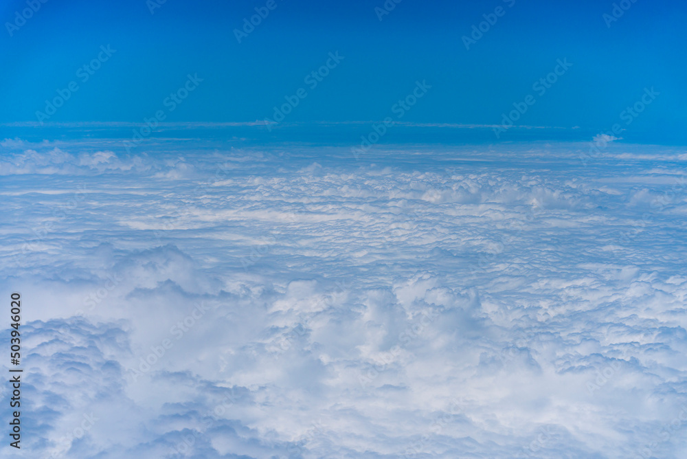 飛行機の窓から眺める空の景色 青空と流れる白い雲