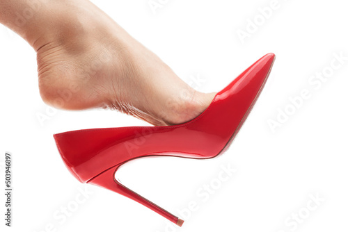 Female foot with red stiletto heels shoe on white background