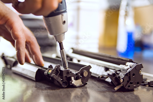 hands repairing laser toner cartridge