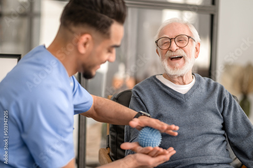 Patient having his hand massaged with a spiky massage ball photo