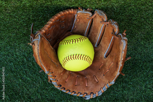 The softball ball in the softball glove has space for text. photo