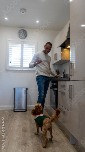 Man with dog in kitchen photo