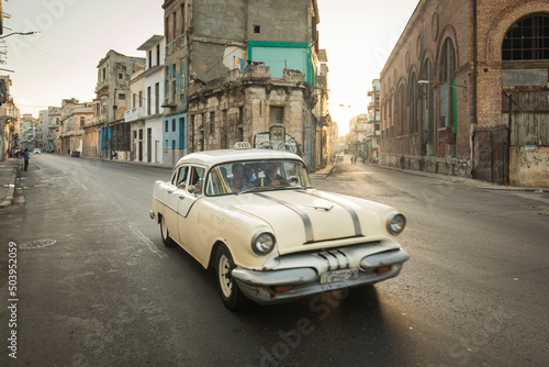 Amazing old american car on streets of Havana with colourful buildings in background. Havana, Cuba.