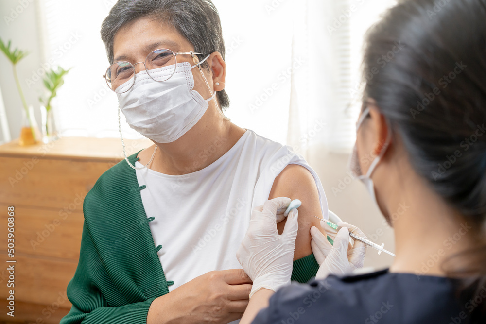 Covid-19,coronavirus, elderly asian adult woman getting vaccine from doctor or nurse giving shot to mature patient at clinic. Healthcare, immunization, disease prevention against flu or virus pandemic