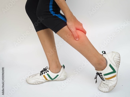 Woman suffering from leg pain, calf pain on white background, health care and medical concept.
