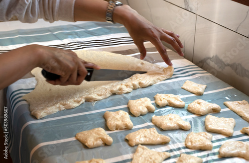 Preparation of traditional Kazakh pastries - baursaks. The woman cuts the dough into pieces. High quality photo