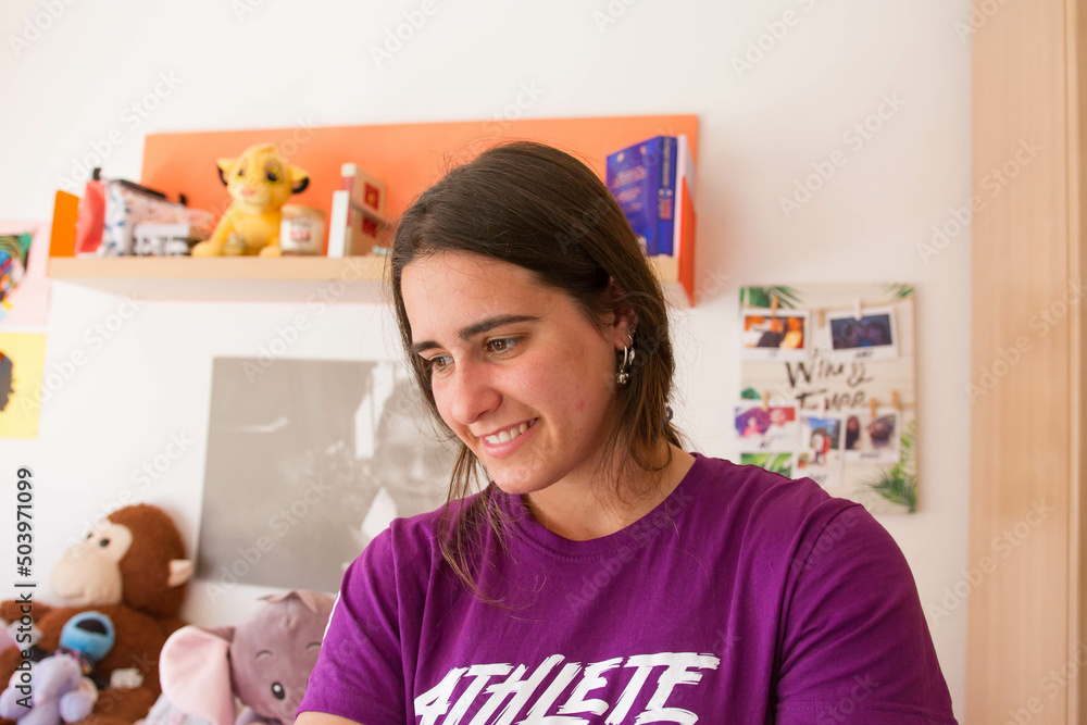 An attractive young girl looking to the side, smiling in the house. An attractive young girl looking to the side, smiling in the house.