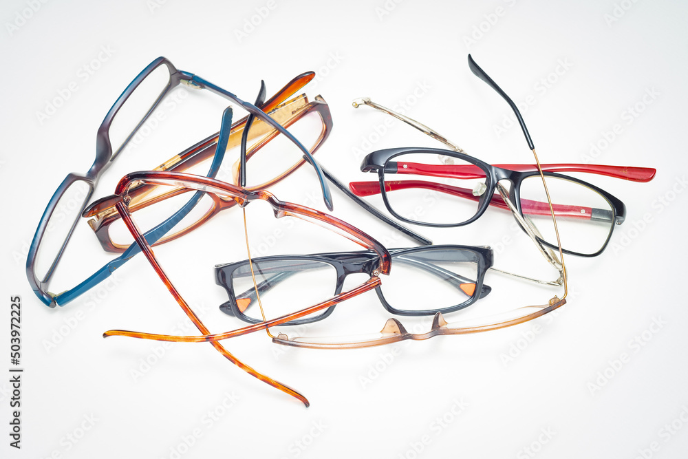 Various used eyeglasses heaped on white background Various used eyeglasses heaped on white background