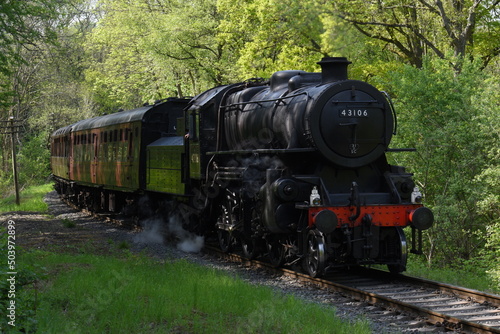 an Ivatt class 4 steam locomotive traveling through an English forest