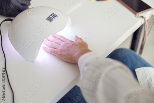 Modern woman during nail care service in salon