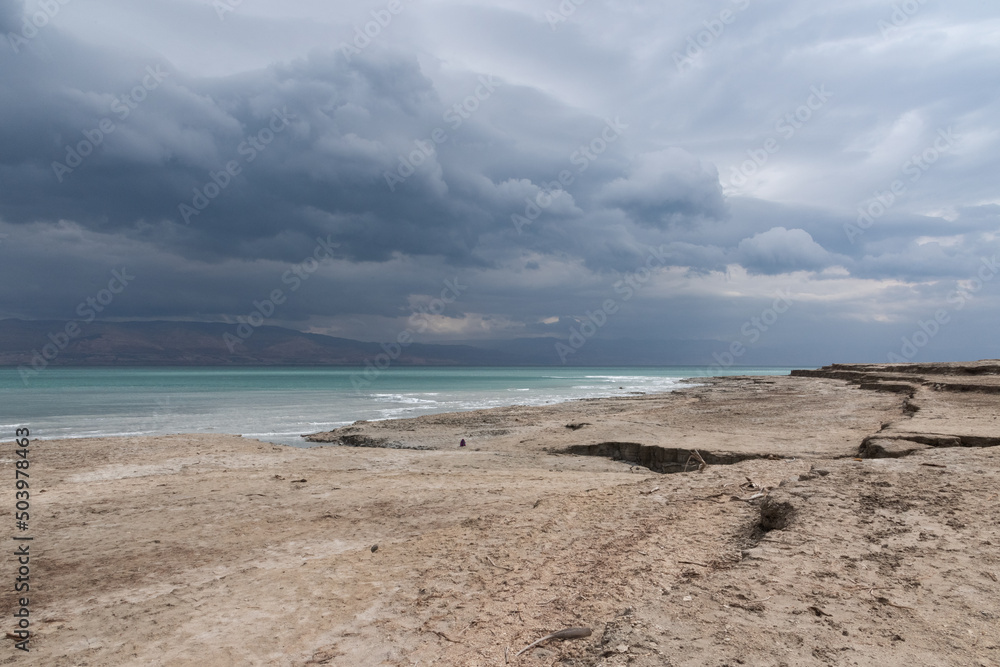 Exotic view of the sinkhole area of the Dead Sea on a stormy winter day. PhotoStorm and rain at the Dead Sea coastline. Salt crystals at sunset. The texture of the Dead sea. Salty seashore. High Exotic view of the sinkhole area of the Dead Sea on a stormy winter day. PhotoStorm and rain at the Dead Sea coastline. Salt crystals at sunset. The texture of the Dead sea. Salty seashore. High