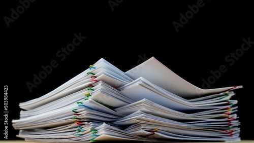 4K-Stop motion Stack overload document report paper with colorful paperclip on black background and copy space, business concept footage paperless used.
