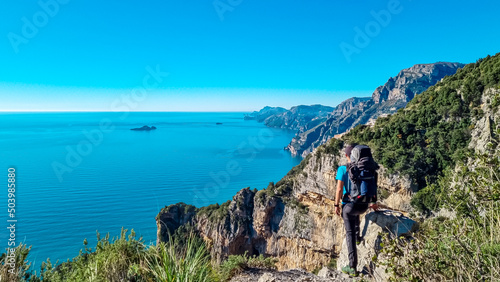 Man with panoramic view from hiking trail Path of Gods between coastal towns Positano and Praiano. Trekking in Lattari Mountains, Apennines, Amalfi Coast, Campania, Italy, Europe. Mediterranean Sea © Chris