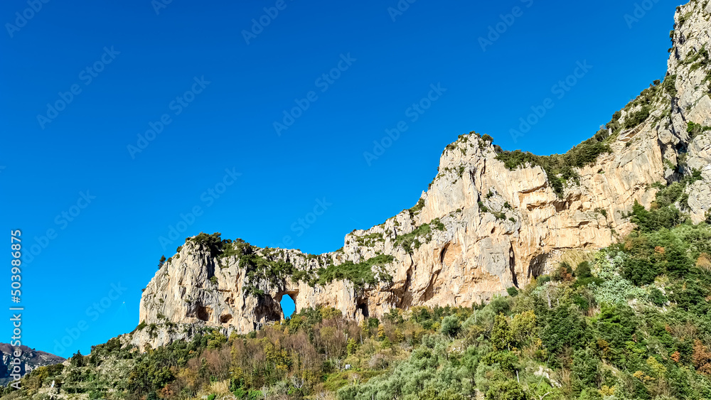 Scenic view on rock formation Montepertuso Il Buco on hiking trail Path of Gods between Positano and Praiano, Amalfi Coast, Campania, Italy, Europe. Hole in a cliff rock at the Mediterranean Sea