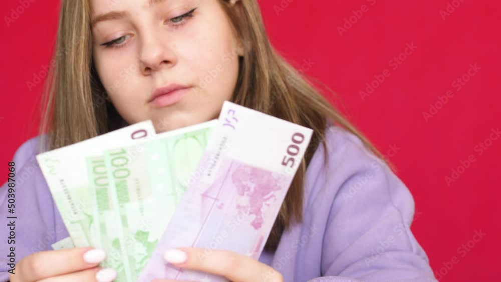 Cheerful attractive Caucasian young woman 20-21 years old holds in her hands and counts cash euro banknotes. European girl counts cash close-up.Selective focus Cheerful attractive Caucasian young woman 20-21 years old holds in her hands and counts cash euro banknotes. European girl counts cash close-up.Selective focus