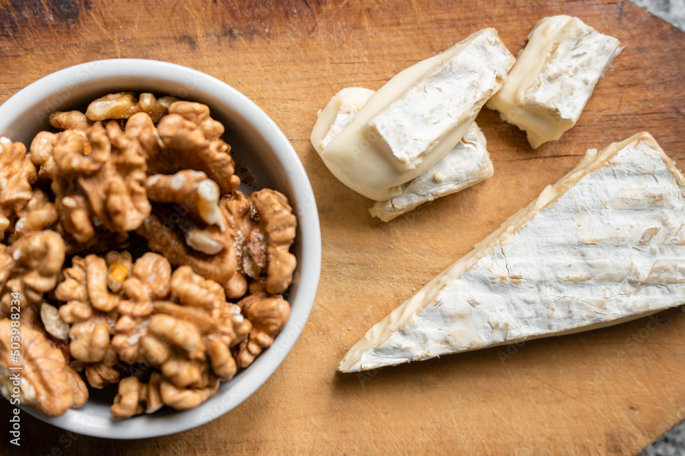Portion of Brie cheese with walnuts. Top view Portion of Brie cheese with walnuts. Top view