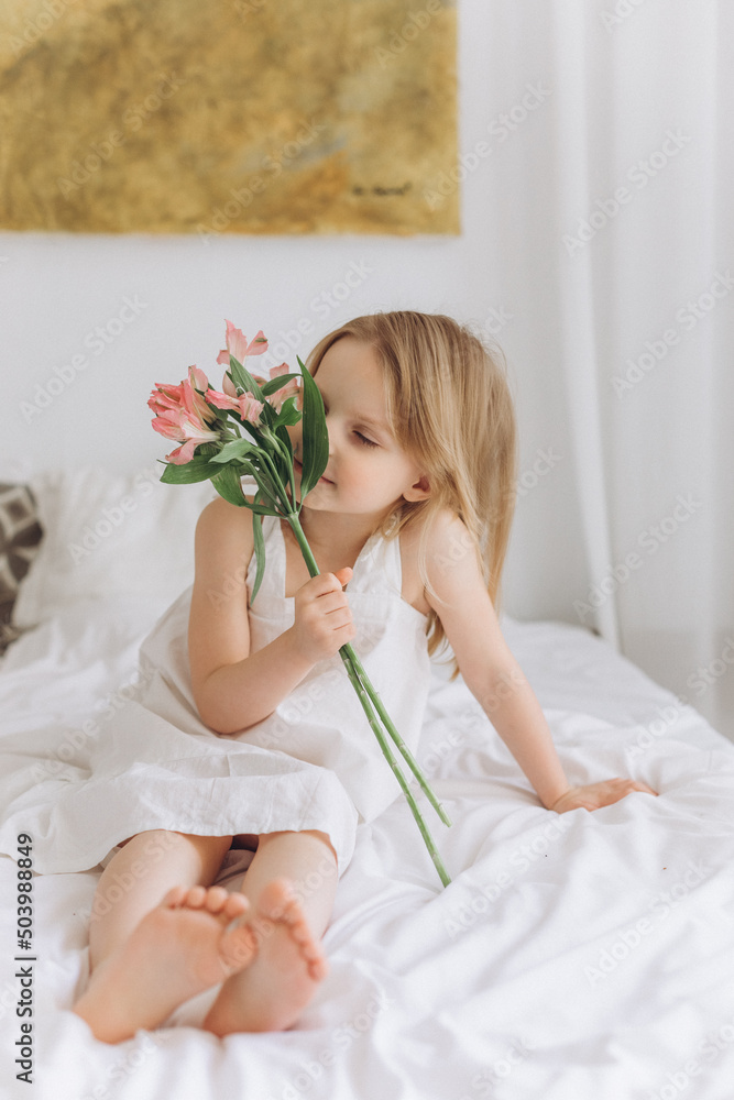 Cute little blondie cheerful girl with plants at home Cute little blondie cheerful girl with plants at home