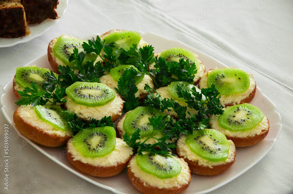 sandwiches with kiwi and grated cheese. healthy food concept. light breakfast illustration. holiday snacks in a white plate. sandwiches with kiwi and grated cheese. healthy food concept. light breakfast illustration. holiday snacks in a white plate.