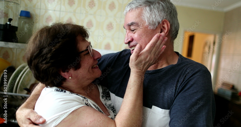 Casual older couple showing love and affection. Senior wife kissing husband at home Casual older couple showing love and affection. Senior wife kissing husband at home