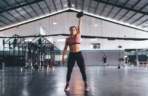 Strong woman in sportswear have weightlifting practice training in gym studio,Caucaisan female with dumbbell exercising during workout for physical recreation - concept of endurance and pursuit effort © BullRun