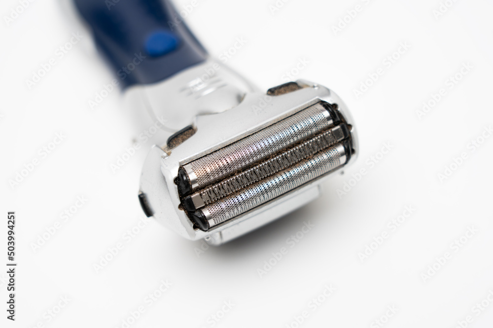 Disassembled electric shaver with remnants of hair close up on a white background Disassembled electric shaver with remnants of hair close up on a white background