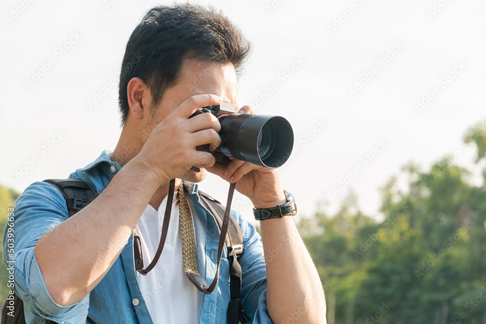 Asian man photographer shooting landscape picture with camera outdoor at park, travel, career freelancer or leisure activity concept, with copy space Asian man photographer shooting landscape picture with camera outdoor at park, travel, career freelancer or leisure activity concept, with copy space