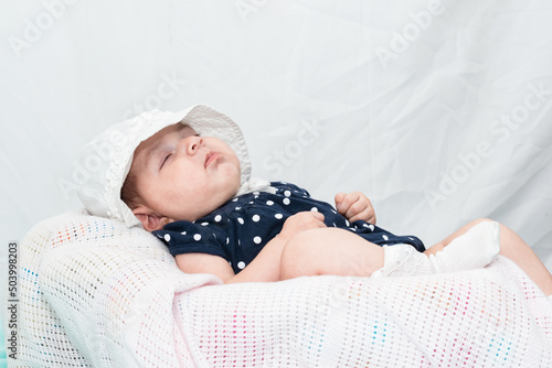 baby resting on a white pillow, after a long night awake. latina babe lying on a white pillow on a white background. concept of health and life. photo