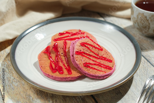 Pink pancakes decorated red jam.