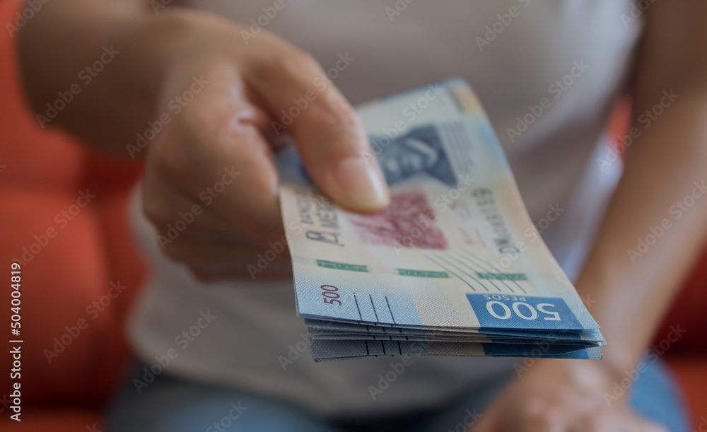 Manos ofreciendo 500 pesos mexicanos Manos ofreciendo 500 pesos mexicanos