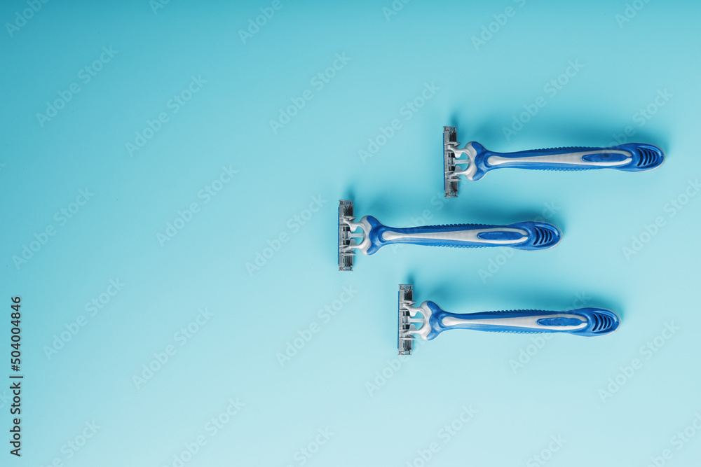 Blue shaving machines in a row on a blue background with ice cubes Blue shaving machines in a row on a blue background with ice cubes