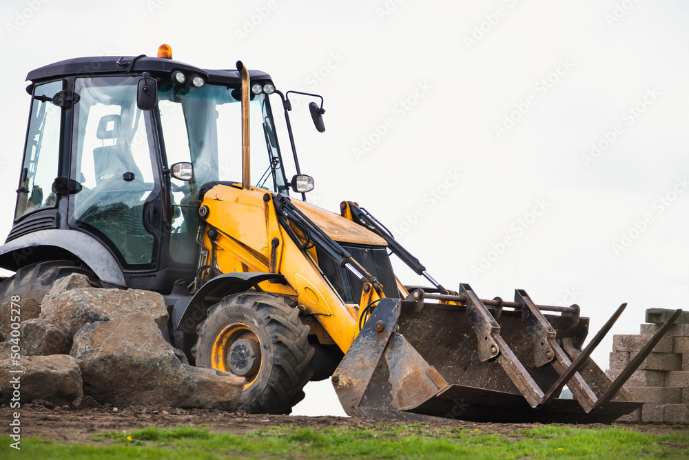 Bulldozer on Rubber Wheels Works on Construction Site. equipped with a substantial metal plate also known as a blade. Used to push large quantities of soil, sand, rubble, etc, during construction work Bulldozer on Rubber Wheels Works on Construction Site. equipped with a substantial metal plate also known as a blade. Used to push large quantities of soil, sand, rubble, etc, during construction work
