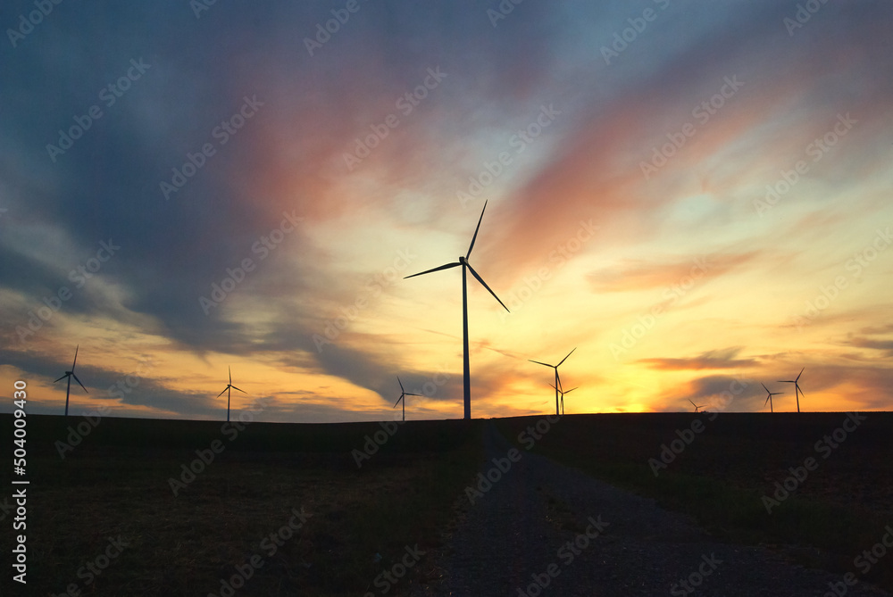 wind farm windmills in dramatic light and mystical sunset atmosphere