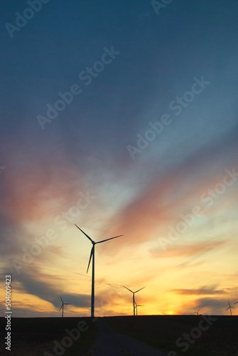 Obraz na płótnie wind farm windmills in dramatic light and mystical sunset atmosphere w salonie