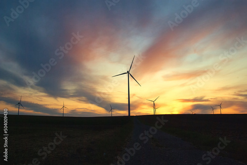 Obraz na płótnie wind farm windmills in dramatic light and mystical sunset atmosphere w salonie