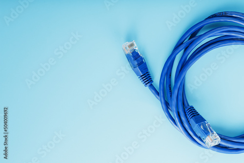 Blue Ethernet Cable Cord Patch cord on a blue background with free space photo